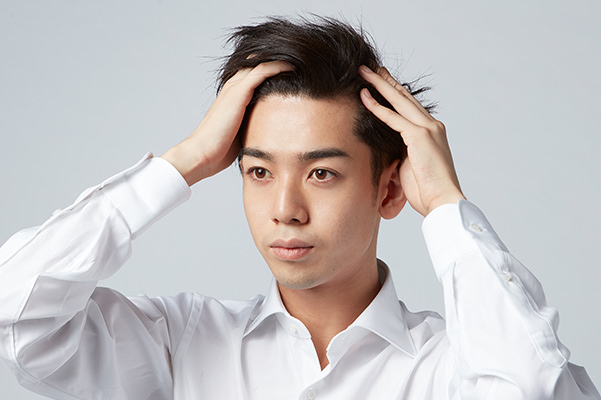 スタイリング剤をなじませる男性の画像