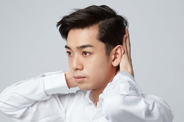 セットした髪のボリュームを抑える男性の画像