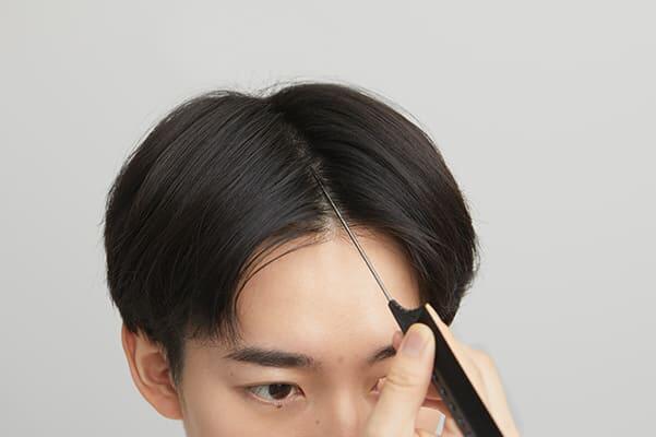 コームの柄を小刻みにジグザグさせながら分け目を作る