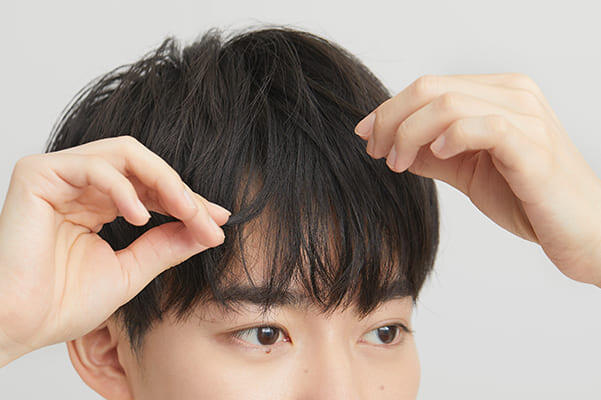前髪の束感をつくる男性