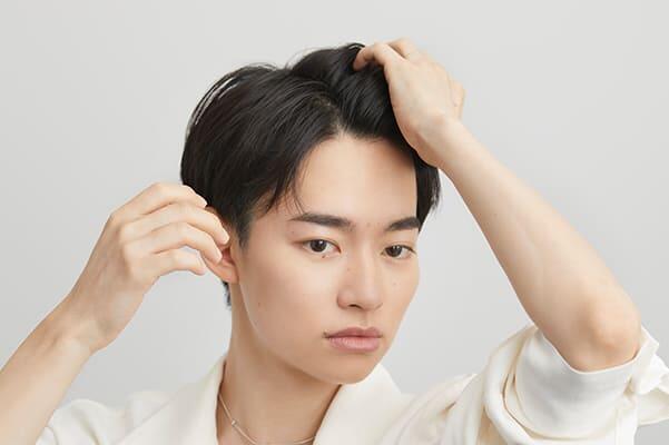 髪全体にワックスをなじませる男性