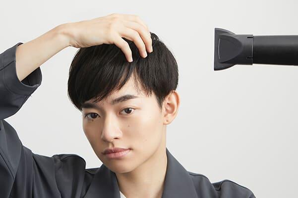 ドライヤーをあてる男性画像