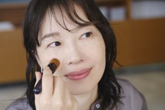 女性がファンデーションブラシでベースメイクを仕上げている