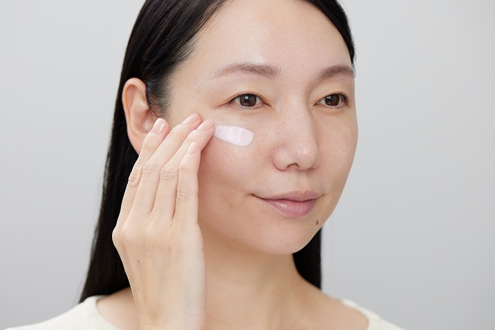 化粧下地をほおに塗っている女性