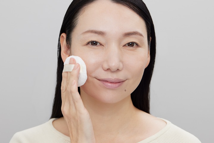 パウダーをパフで塗っている女性