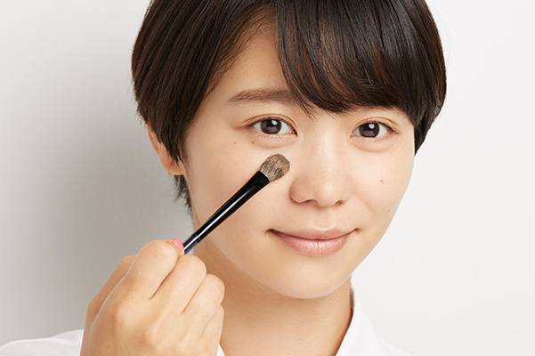 ブラシでおしろいをTゾーンになじませている様子