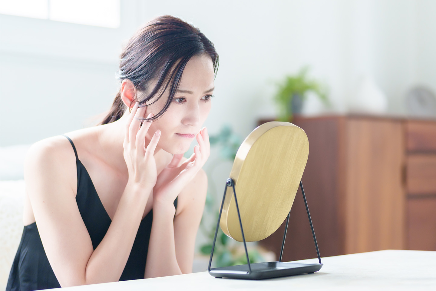 鏡で自分の顔を見ている女性