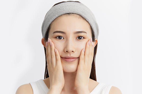 顔に手を当てている女性