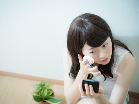 肌荒れをメイクで隠そうとする女性